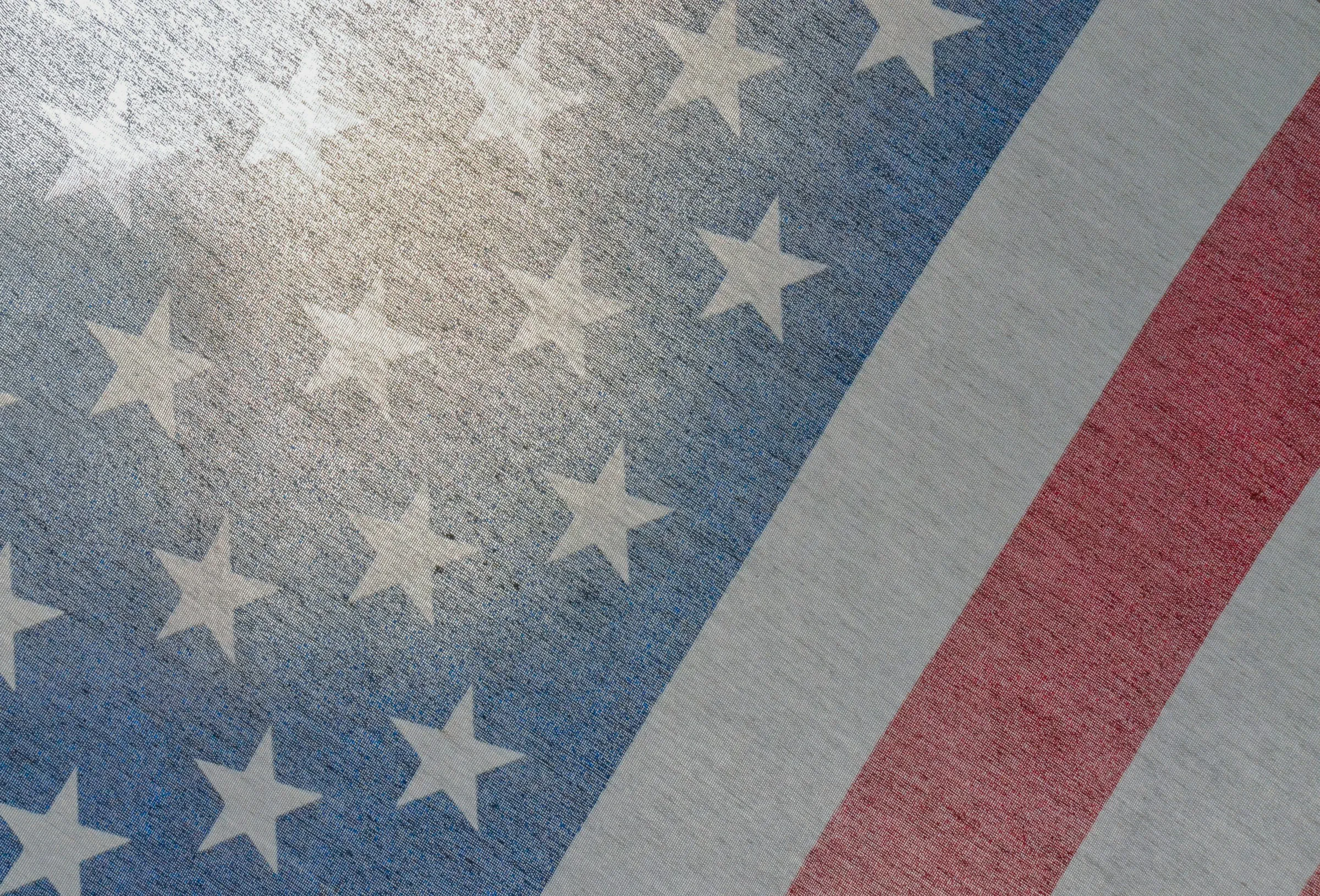 close up shot of an American flag with sunlight streaming through the cloth