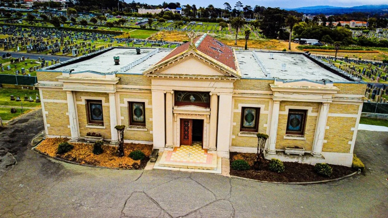 el-camino-mausoleum Small yellow brick structure featuring doric and ionic columns and a red shingled roof